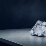 Feuille de plainte froissée posée sur un bureau vide dans une ambiance froide bleu nuit et gris clair, symbolisant le déni institutionnel et l'absence de réponse aux victimes.