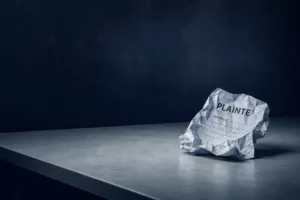 Feuille de plainte froissée posée sur un bureau vide dans une ambiance froide bleu nuit et gris clair, symbolisant le déni institutionnel et l'absence de réponse aux victimes.